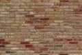 Beautiful antique brick wall texture sprinkled with hot pepper hued bricks of red, tan, pink and brown, with arched window Royalty Free Stock Photo