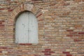 Beautiful antique brick wall texture sprinkled with hot pepper hued bricks of red, tan, pink and brown, with arched window Royalty Free Stock Photo