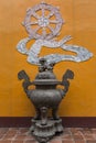 Beautiful antique bronze incense burner against orange wall