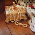 A beautiful antique golden jewelry box with natural white pearls on wooden table Royalty Free Stock Photo