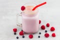 Beautiful appetizer pink raspberries and blueberry fruit smoothie or milkshake in glass jar with berries background. Yogurt Royalty Free Stock Photo
