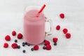 Beautiful appetizer pink raspberries and blueberry fruit smoothie or milkshake in glass jar with berries background. Yogurt Royalty Free Stock Photo