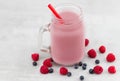 Beautiful appetizer pink raspberries and blueberry fruit smoothie or milkshake in glass jar with berries background. Yogurt Royalty Free Stock Photo