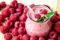 Beautiful appetizer pink raspberries fruit smoothie or milk shake in glass jar with berries background, top view.