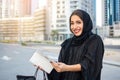 Beautiful Arab woman with shy smile opening empty wallet. Royalty Free Stock Photo