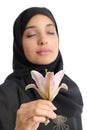 Beautiful arab woman wearing a hijab smelling a flower