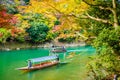 Beautiful Arashiyama river with maple leaf tree and boat around lake