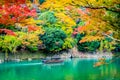 Beautiful Arashiyama river with maple leaf tree and boat around lake