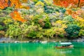 Beautiful Arashiyama river with maple leaf tree and boat around lake