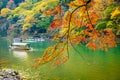 Beautiful Arashiyama river with maple leaf tree and boat around lake