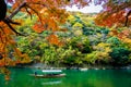 Beautiful Arashiyama river with maple leaf tree and boat around lake