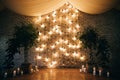 A beautiful arch for a wedding ceremony is decorated with lights
