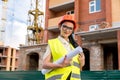 Beautiful architect with blueprints in rolls on construction site Royalty Free Stock Photo