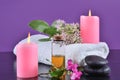 Beautiful arranged desk in spa and beauty salon with pink candle, towel, bottle with oil and flowers Royalty Free Stock Photo