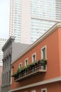 Pretty balcony outside stucco-front home, with flowers greeting passing people below