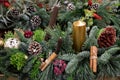 Beautiful arrangement from natural cones, red berries, cinnamon sticks, sprigs of pine, spruce, cypress and golden candle for