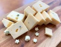 A Beautiful Array of Cheese Dices and Slices on a Rustic Wooden Board