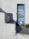 A Beautiful Artful Photograph with a Blue Rustic Door Against a White Washed Building with Steps
