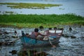 A person driving a boat in the wonderful pond filled with lotus plants