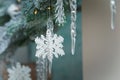 Beautiful artificial fir tree branches with snowflakes and icycles toys. Merry Christmas Happy New Year decorative elements.