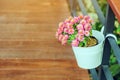 Beautiful artificial flowers in small pots hanging to decorate a railing walk for beauty on the pathway in public gardens.