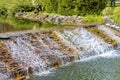 Decorative waterfall in the summer garden. Running water along a dripping slope. Landscape design Royalty Free Stock Photo