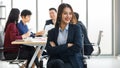 Beautiful Asain businesswoman sitting and holding arms with her team blur in background Royalty Free Stock Photo