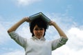 Asia woman holding and reading book on sky background. Royalty Free Stock Photo