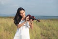 Beautiful asia girl white dress playing on a violin Royalty Free Stock Photo