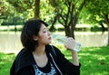 Asia sport woman holding green apples and walking in public park.