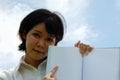 Asia woman holding and reading book on sky background. Royalty Free Stock Photo