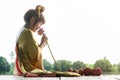 Beautiful asia women wearing traditional Thai dress and sitting on Wooden floor. Her hands is holding lotus flower and smell pink Royalty Free Stock Photo