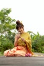 Beautiful asia women wearing traditional Thai dress and sitting on wooden bridge. Her hand is in the respect hands in thailand sty Royalty Free Stock Photo