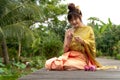 Beautiful asia women wearing traditional Thai dress and sitting on wooden bridge. Her hand is in the respect hands in thailandBeau Royalty Free Stock Photo