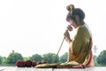 Beautiful asia women wearing traditional Thai dress and sitting on Wooden floor. Her hands is holding lotus flower and smell pink Royalty Free Stock Photo