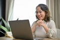 Beautiful Asian-aged businesswoman working in her home living room, using laptop. work from home Royalty Free Stock Photo