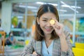 Beautiful asian business woman in close up shot hold a coin in her one hand and covered on her eyes