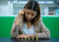 Beautiful asian business woman gazed at the coins in her hand with a thoughtful expression Royalty Free Stock Photo