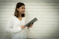 Beautiful asian business woman has an idea to develop the company with her idea while standing and holding tablet Royalty Free Stock Photo