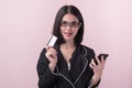 Beautiful asian business woman showing thumb up to recommend credit card in her hand isolated on pink background Royalty Free Stock Photo