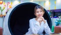 Beautiful asian business woman sitting on a modern round chair appears to be in thought on the table has her phone and tablet. Royalty Free Stock Photo