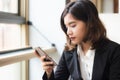 A beautiful asian business woman sitting on sofa holding and using smart phone Royalty Free Stock Photo