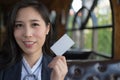 Beautiful asian business woman smile and holds blank white business or credit card isolated on white background. Royalty Free Stock Photo