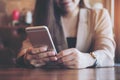 A beautiful Asian business woman with smiley face using and looking at smart phone Royalty Free Stock Photo