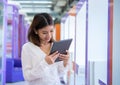 Beautiful asian business woman is standing and looking down at her tablet with a happy expression, Digital marketing Royalty Free Stock Photo