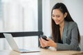 Beautiful asian business woman using smartphone working in office Royalty Free Stock Photo