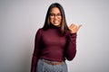 Beautiful asian business woman wearing casual sweater and glasses over white background smiling with happy face looking and Royalty Free Stock Photo