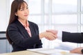 Beautiful Asian business woman wears a black suit and hand in hand with a partner and smile confidently.