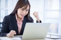 Beautiful Asian business woman wore a black suit sitting in the office, smiling happily when the job project was successful. Royalty Free Stock Photo