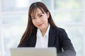 Beautiful Asian businessman wearing a black suit sitting in the office, smiling confidently and looking at the camera Royalty Free Stock Photo